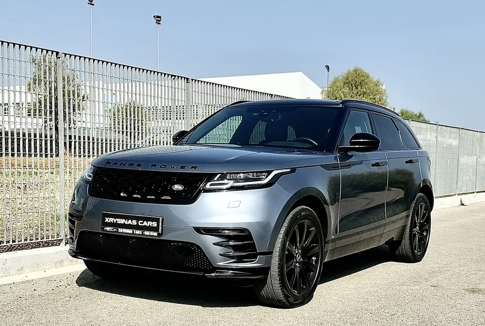 Γκρι Range Rover Velar από το απόθεμά μας, δίπλα σε μεταλλικό φράχτη